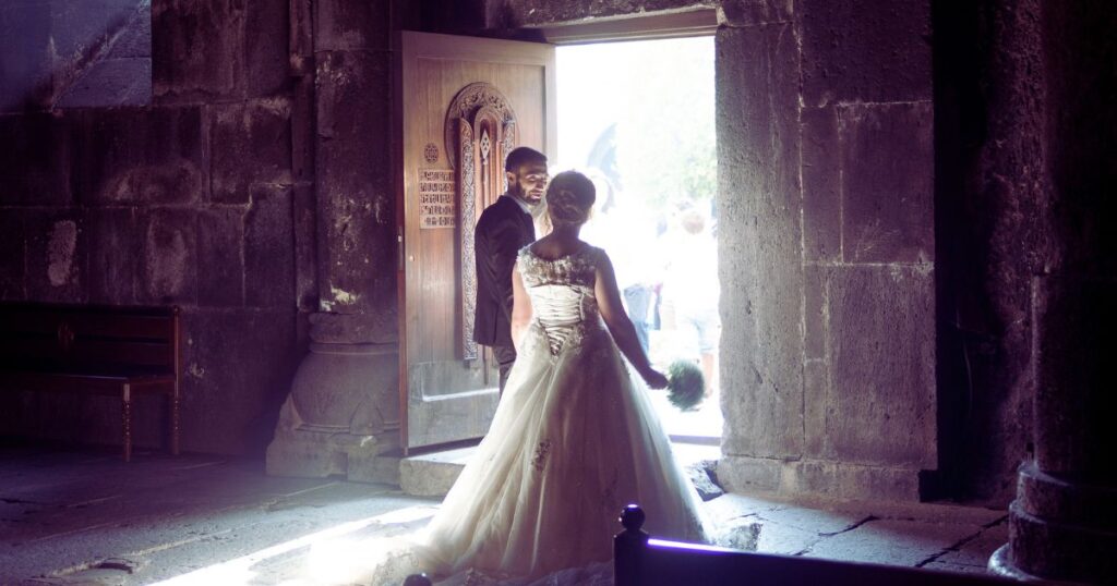 a bride and groom wait at the door of a church, illustrating the theme of weddings in dreams.